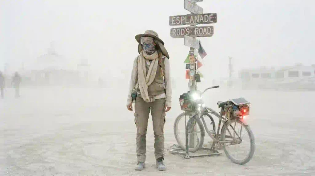  Burner in goggles and dust mask using playa navigation signs during a Burning Man dust storm
